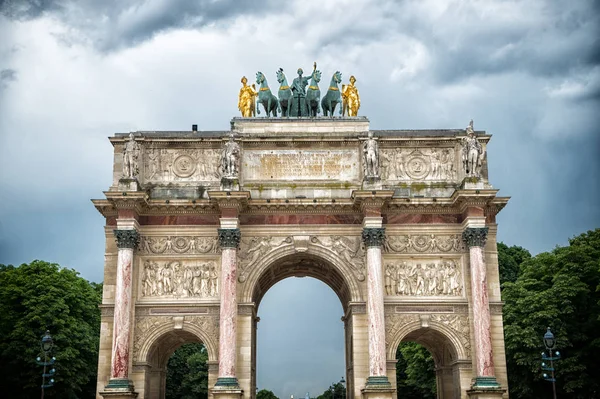 Arc de triomphe du carrousel in paris, france. Monumento al arco y árboles verdes en el cielo nublado. Símbolo arquitectónico de victoria por la paz y la fama. Vacaciones y ansia de viajar en la capital francesa — Foto de Stock