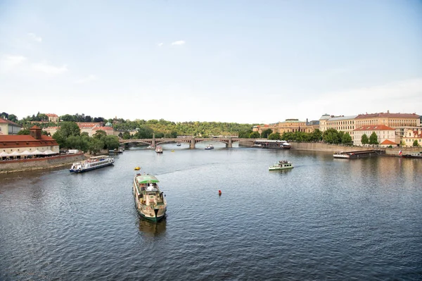 Praga, Repubblica Ceca - 03 giugno 2017: Barche da diporto sul fiume Moldava. viaggiare con trasporto per via navigabile. Navi da crociera vacanze sul paesaggio urbano sul cielo blu. Vacanze estive e vagabondaggio — Foto Stock