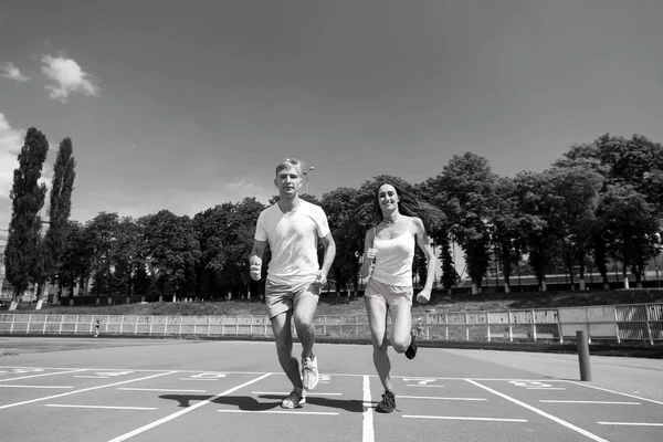 Pareja corriendo en pista de arena — Foto de Stock