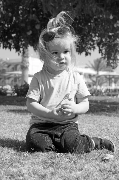 Niño pequeño con cara adorable en hierba verde — Foto de Stock