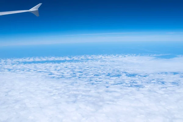 Nubes y cielo visto a través de la ventana de la aeronave — Foto de Stock