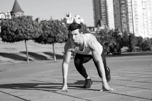 Fitter Macho in Trainingsanzug und Laufschuhen auf urbanem Terrain — Stockfoto