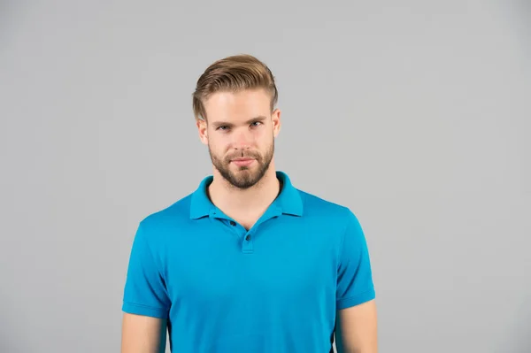 Mens beauty, fashion and style. Man in blue tshirt on grey background. Guy with bearded unshaven face. Macho with blond hair and stylish haircut. Hair care in salon or barbershop. — Stock Photo, Image
