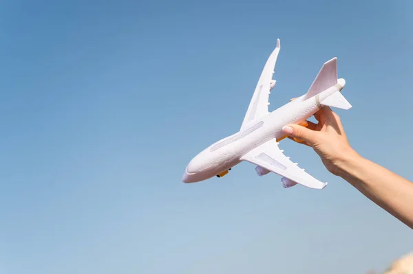 Modelo de avión en mano. Avión en el cielo azul. Jet o juguete de avión en soleado al aire libre. Viaje en transporte aéreo, aviación. Símbolo de la lujuria del viajero, viaje y vacaciones. Concepto de sueño e imaginación, espacio de copia — Foto de Stock