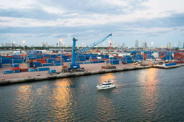 Miami, Amerikai Egyesült Államok - március 01, 2016: tengeri konténeres Kikötői daruk és teherhajó. Yacht úszó mentén tengeri kikötő és a terminál vagy a dokk. Áru szállítás, szállítás, logisztika és az áru fogalma — Stock Fotó