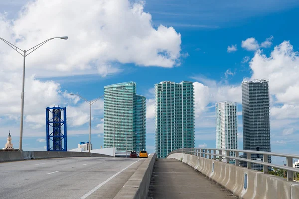 Carretera con coches y rascacielos de miami, EE.UU. Carretera o carretera para el tráfico de transporte en el cielo azul nublado. Concepto de infraestructura pública. Viajar y viajar en coche — Foto de Stock