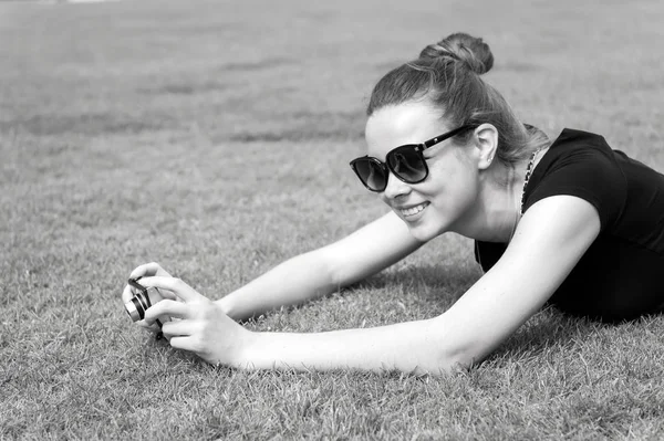 Szczęśliwa dziewczyna z aparatem fotograficznym na zielonej trawie w Paryżu, Francja — Zdjęcie stockowe