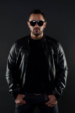 Acımasız maço deri ceketli. Sakallı adam moda güneş gözlüğü. Erkek cinsellik ve cazibe. Moda modeli Güneş gözlüğü. Sakallı adam şık bir görünüme sahiptir. Trendy kıyafetler Musuclar atlet