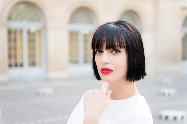 Donna con capelli castani e labbra rosse trucco viso a Parigi, Francia — Foto Stock