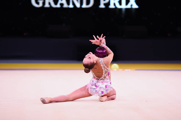 гимнастка выступает на соревнованиях по художественной гимнастике
