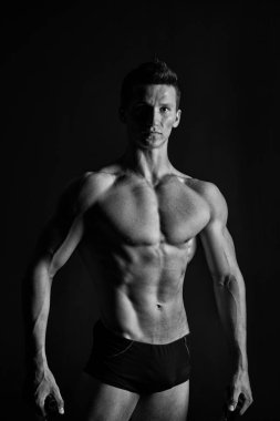 Altı paket ve ab kaslı sporcu. Adam vücut geliştirmeci fit vücut ile. Maço seksi gövde ve göğüs. Eğitim ve egzersiz etkinlik içinde jimnastik salonu. Spor fitness ve welness kavramı, siyah ve beyaz.