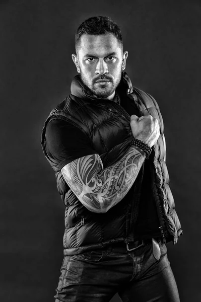 Macho with tattoo on strong arm. Tattooed muscular man in trendy clothes. Fashion athlete with confidence and charisma. Tattoo model with beard and glasses on face. style and trend, black and white — Stock Photo, Image