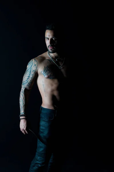 Deporte o fitness y cuidado del cuerpo. Hombre barbudo con cuerpo tatuado. Macho con torso desnudo sexy en jeans. Modelo de tatuaje con seis paquetes y ab. Atleta o deportista con pecho y vientre musculosos — Foto de Stock