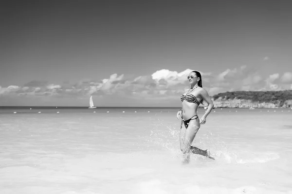 Donna in bikini correre sulla spiaggia in st johns, antigua — Foto Stock