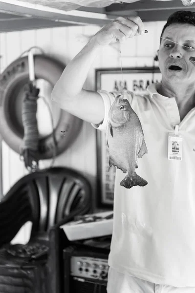 Glada mannen i gul tshirt håller fisk på rad — Stockfoto