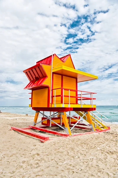 Rettungsschwimmerhaus am Sandstrand in Miami, USA. Turm für Rettungsbajwatch im typischen Art-déco-Stil. Holzhaus am Meeresufer bei bewölktem Himmel. Sommerferienkonzept. Öffentliche Bewachung und Sicherheit — Stockfoto