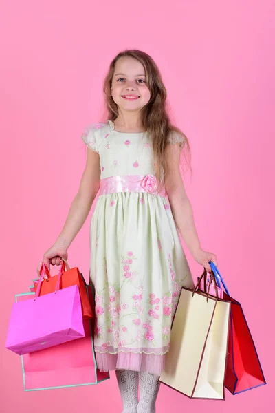 Dívka s šťastný obličej drží nákupní tašky na růžovém pozadí — Stock fotografie