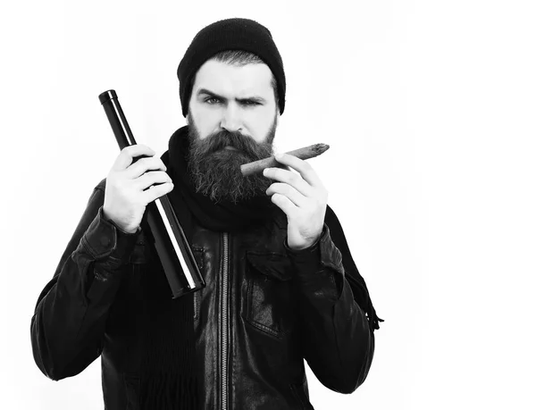 Brutalny, biały hipster trzymający butelkę i palący cygaro — Zdjęcie stockowe