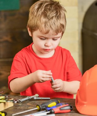 Metal ile oynayan Closeup çocuk cıvata. Küçük işçi atölye. Kırmızı T-shirt masanın arkasında şirin çocuk
