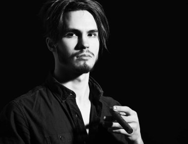 Sigara içen ciddi sakallı bir adam.