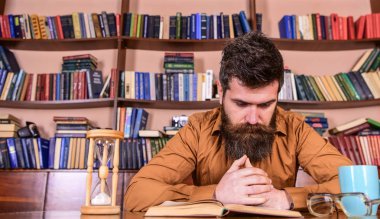 Eğitim, kitap rafı arka plan üzerinde konsantre yüz kitap, okuma kişi. Öğretmen ya da sakal Kitaplığı'nda eğitim ile öğrenci. Adam, kupa ve kum saati ile masada oturur. Kendi eğitim kavramı