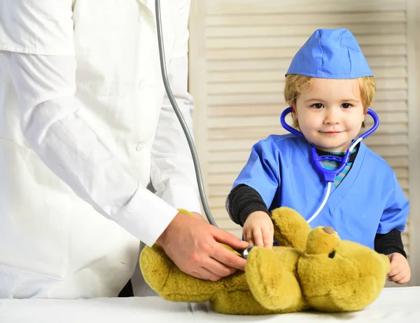 Concepto de salud e infancia. Pequeño asistente examina osito de peluche . —  Fotos de Stock