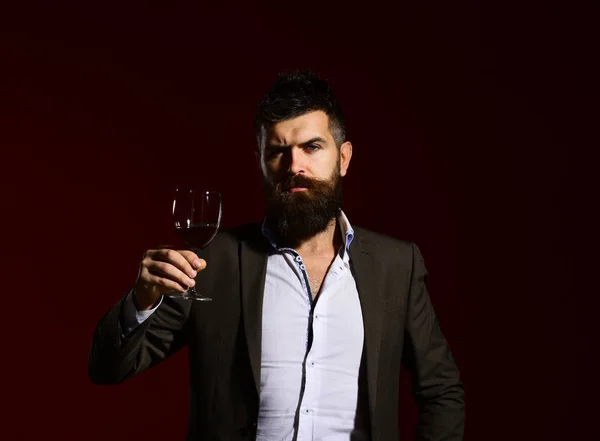 Man in suit toasting with sparkling glass of red wine — Stock Photo, Image