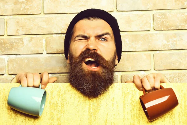 Barbudo brutal hipster caucásico con hoja de papel y tazas —  Fotos de Stock