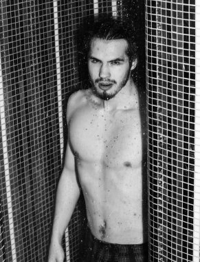 Yakışıklı kaslı seksi adam duşta yıkanıyor.