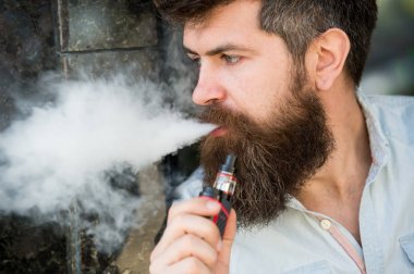 Adam duman e-sigara vurguladı. Yan görünümü vape teneffüs edilmesi adam sakallı. Stres rahatlama ve gevşeme kavramı