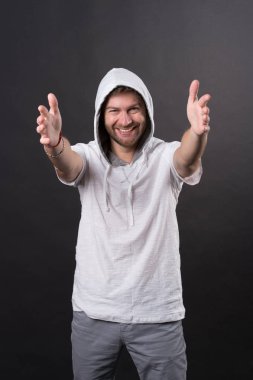 Sakallı adam gergin elleriyle gülümse. Sakal aşınma kukuleta ile mutlu bir adam. Kapüşonlu tişörtü moda modeli. Aktif yaşam tarzı ve sağlık aktivite. Moda stil ve eğilim kavramı