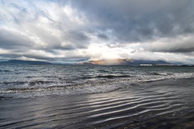 Reykjavik, İzlanda kumlu plajda dalgalar deniz. Bulutlu gökyüzü gri su ile deniz manzarası. Doğanın gücünü. Yolculuk tutkusu veya seyahat ve tatil