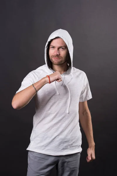 Hombre en el capó con el puño cerrado gesto. Hombre barbudo con sudadera casual. Modelo de moda en camiseta con capucha. Estilo de vida activo y actividad sanitaria. Estilo de moda y concepto de tendencia — Foto de Stock