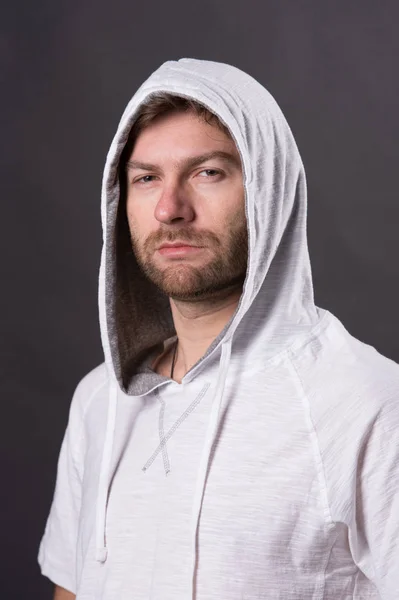 Salón de peluquería y cuidado de la piel concepto. El hombre con la barba lleva capucha. Hombre barbudo con sudadera casual. Modelo de moda con la cara sin afeitar. Estilo y tendencia de moda — Foto de Stock