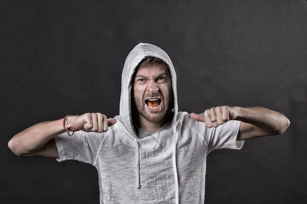 Un hombre enojado con puños de barba. El hombre barbudo usa capucha. Modelo de moda en camiseta con capucha. Estilo de vida activo y actividad sanitaria. Estilo de moda y concepto de tendencia, filtro vintage — Foto de Stock