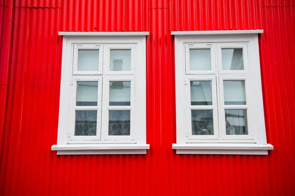 Ventanas en la casa en Reikiavik, iceland. Fachada de edificio con paredes rojas y marcos de ventanas blancas. Estructura y diseño de arquitectura — Foto de Stock