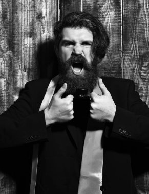 Takım elbiseli beyaz hippi parfüm tutuyor.