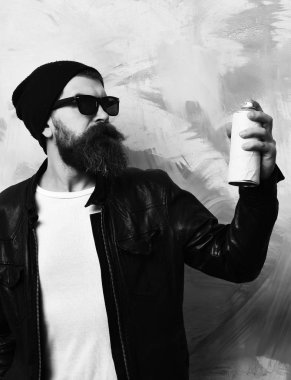 Sakallı vahşi beyaz hippi elinde sprey boya tutuyordu.