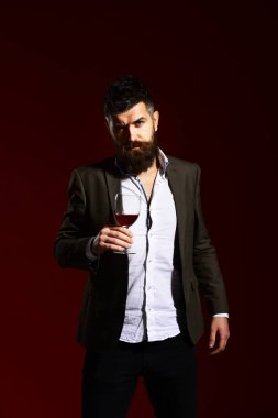 Burgonya kökenli sakallı bir şarap garsonu. Takım elbiseli adam kadeh kaldırıyor.