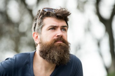 Düşünceli erkek mavi gözlü gökyüzü, huzur ve mindfulness kavramı içine arıyorum. Hipster kafasında parkta dolaşmaya güneş gözlüklü genç sakallı