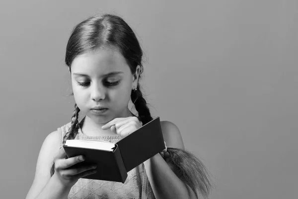 A rapariga lê o livro azul. Escola menina com rosto concentrado — Fotografia de Stock