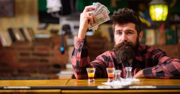 Hipster holds money, counting cash to buy more alcohol.