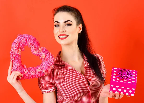 Schönes junges Mädchen mit einem herzförmigen Geschenkkarton — Stockfoto