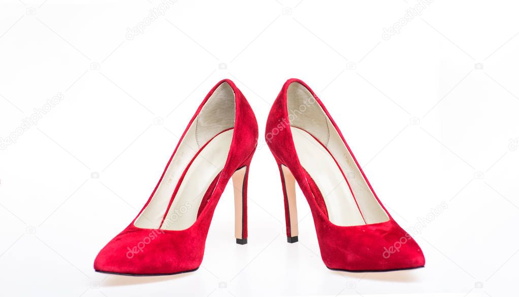 Shoes made out of red suede on white background, isolated. Footwear for women with thin high heels. Elegant stiletto shoes concept. Pair of fashionable high heeled pump shoes
