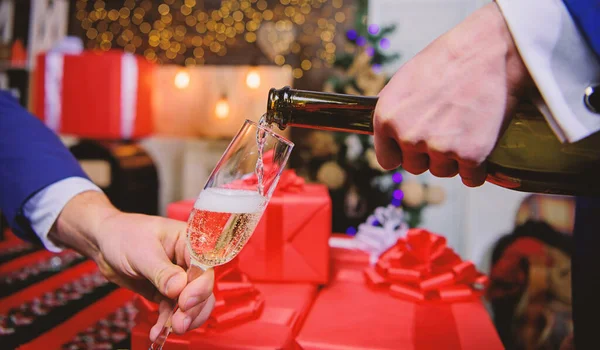 Mani versando champagne in eleganti decorazioni natalizie in vetro sfondo. All'ultimo minuto prima del nuovo anno. Bevi champagne o spumante. Festeggia il nuovo anno con lo champagne. Il concetto di salute — Foto Stock