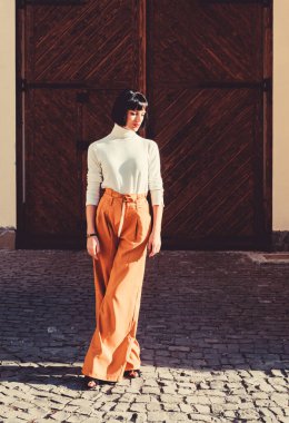 Kadınlık ve kadınsı rakam vurgulamak. Kadın moda kıyafeti. Kız makyaj yüz moda trendi eşleşen giysiler. Stilist moda uzmanı. Yüksek belli pantolonlar podyuma dönmeye devam ediyor. Moda kız