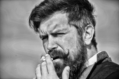 Sakallı hippi sigara gökyüzü arka plan sigara. Adam sigara nikotin etkisi tadını çıkarın. Sigara her şeyi can sıkıntısı ile öfke yönetimi için bize yardım. Sakallı bıyıklı adam tutun Sigara