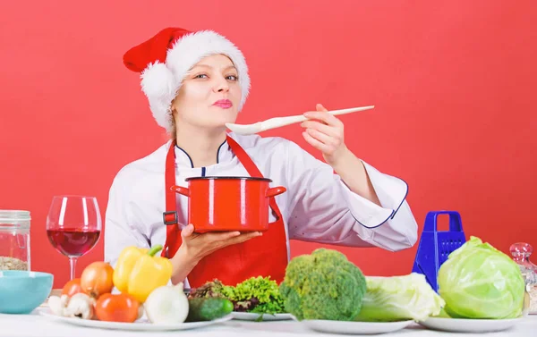 Probeer de hoofdmaaltijd. Eenvoudige ideeën voor het kerstfeest. Gezonde christmas holiday recepten. Vrouw chef-kok santa hat koken houdt houten lepels. Beste Kerst Recepten. Het idee van het diner van Kerstmis. Koken voor familie — Stockfoto