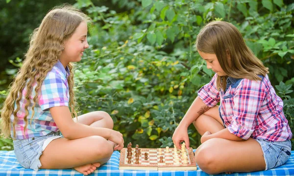 spend time together. family time. two concentrated girls play chess. chess playing sisters. skilled children. turn on your brain. make the brain work. early childhood development. worthy opponents