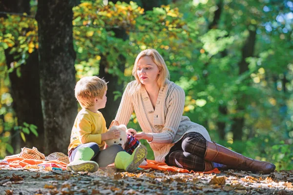 Happy son with mother relax in autumn forest. Family picnic. Mothers day. Sunny weather. Healthy food. Mother love her small boy child. Spring mood. Happy family day. autumn wood picnic
